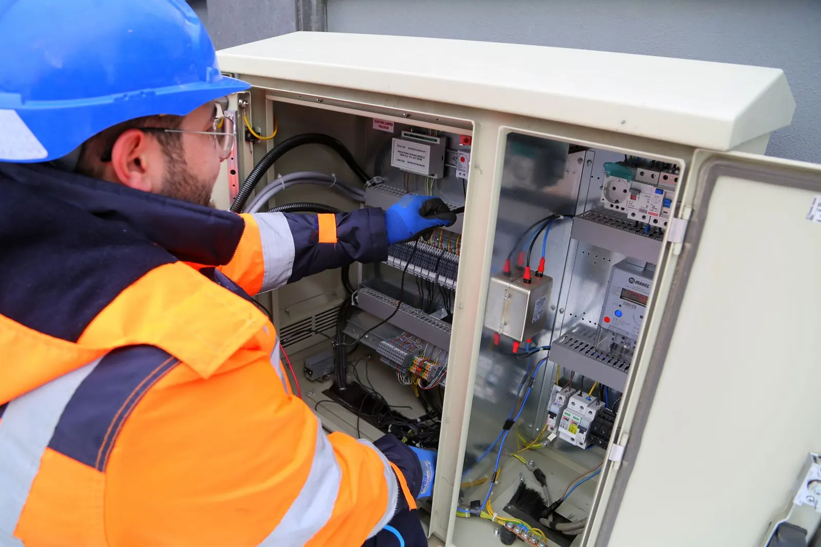 Commercial electrician working in an outdoor electrical panel